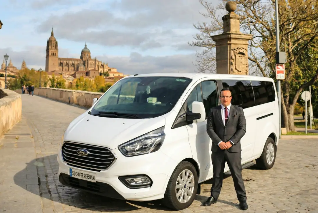 Rafael Iglesias, chófer de Su Chófer Personal, junto a un monovolumen en el Puente Romano de Salamanca